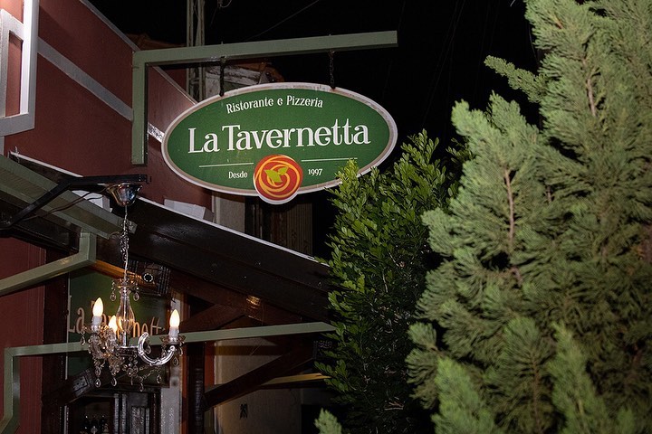 Fachada do restaurante com uma placa escrito La Tavernetta